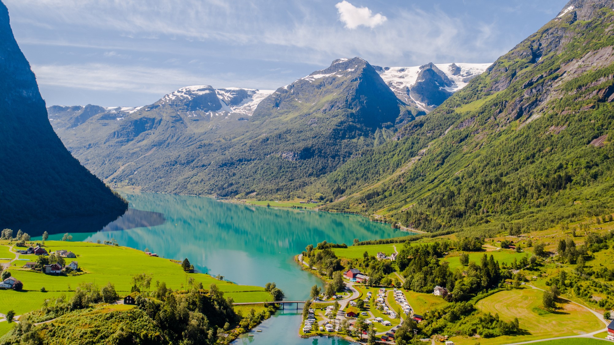 The picturesque and reflective waters of Lake Olden in the Briksdalsbreen Glacier in Sogn og Fjordane, Norway on a bright summer afternoon shot from above using a drone.