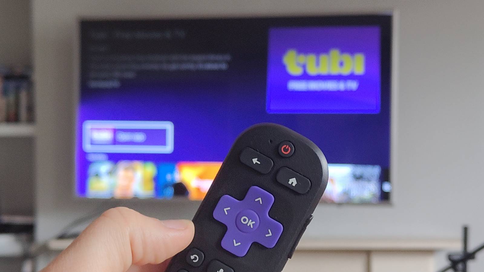 The Roku Streaming Stick's remote in the foreground with the Tubi page in the background.