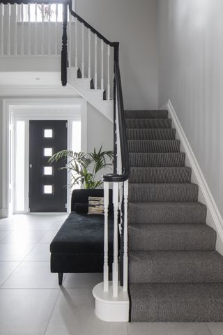 striped black and white carpet on stairs in hallway