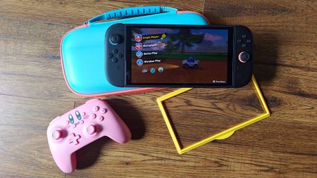 Nintendo Switch 2 sitting on Jsaux case next to Kirby controller and screen protector kit.