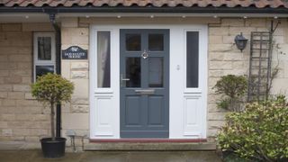 painting a uPVC door - dark blue uPVC door with white framing on light brick house