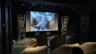 KEF Muon speakers next to a projector screen
