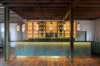 Thames Distillers new home and Fords bar, is an industrial gin brick distillery with a glamorous bar clad in green stone