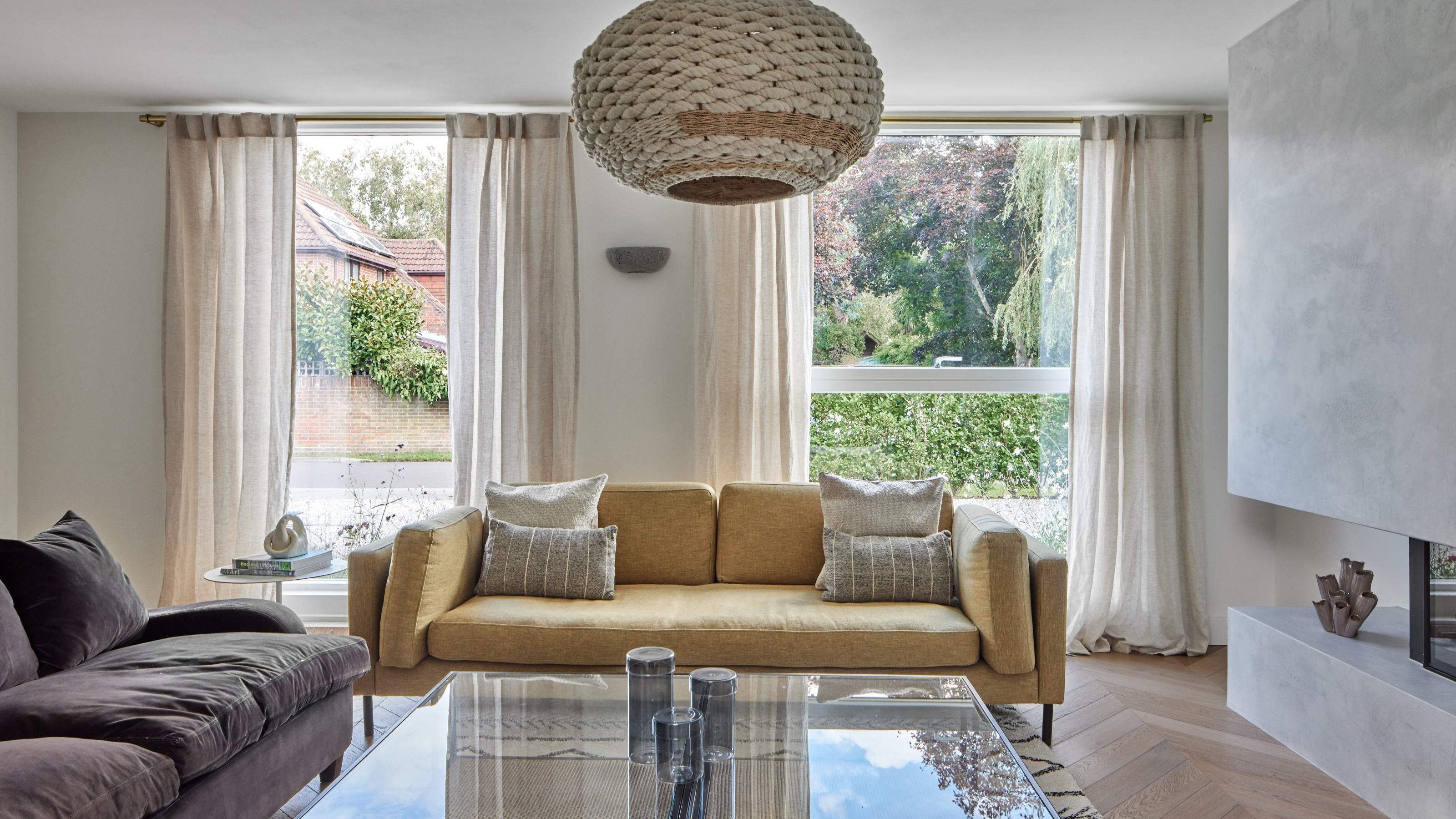 Large living room with huge windows, tow sofas and a large coffee table.