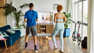 Couple exercise at home with exercise mats in front of them