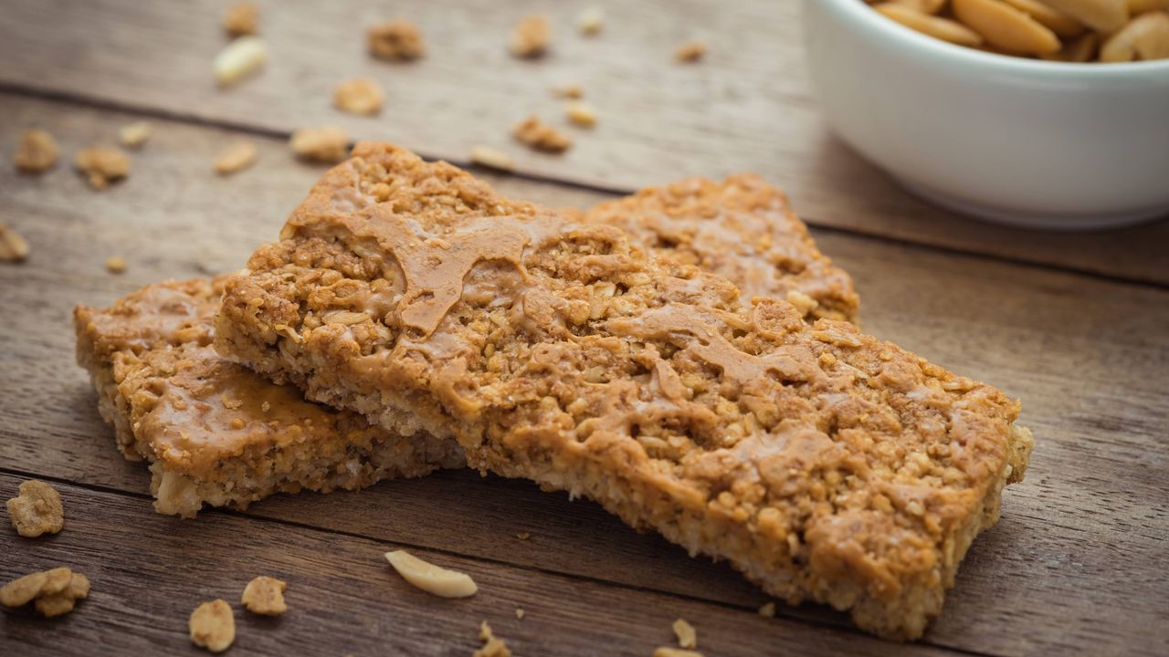 peanut butter flapjacks on a board with bowl of peanuts