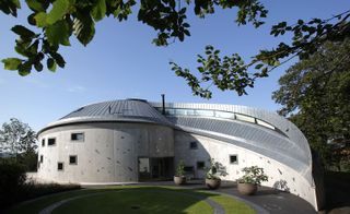 Concrete spiral façade with titanium plates, curved zinc metal roof