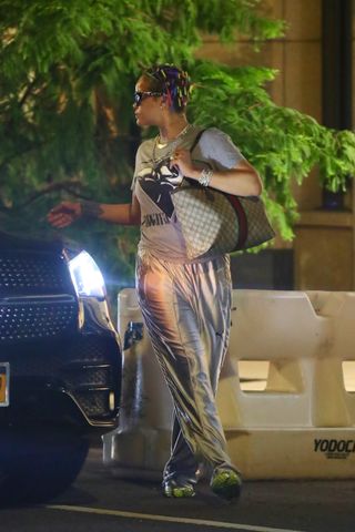 Rihanna gets into a car wearing liquid metal track pants and a gucci bag