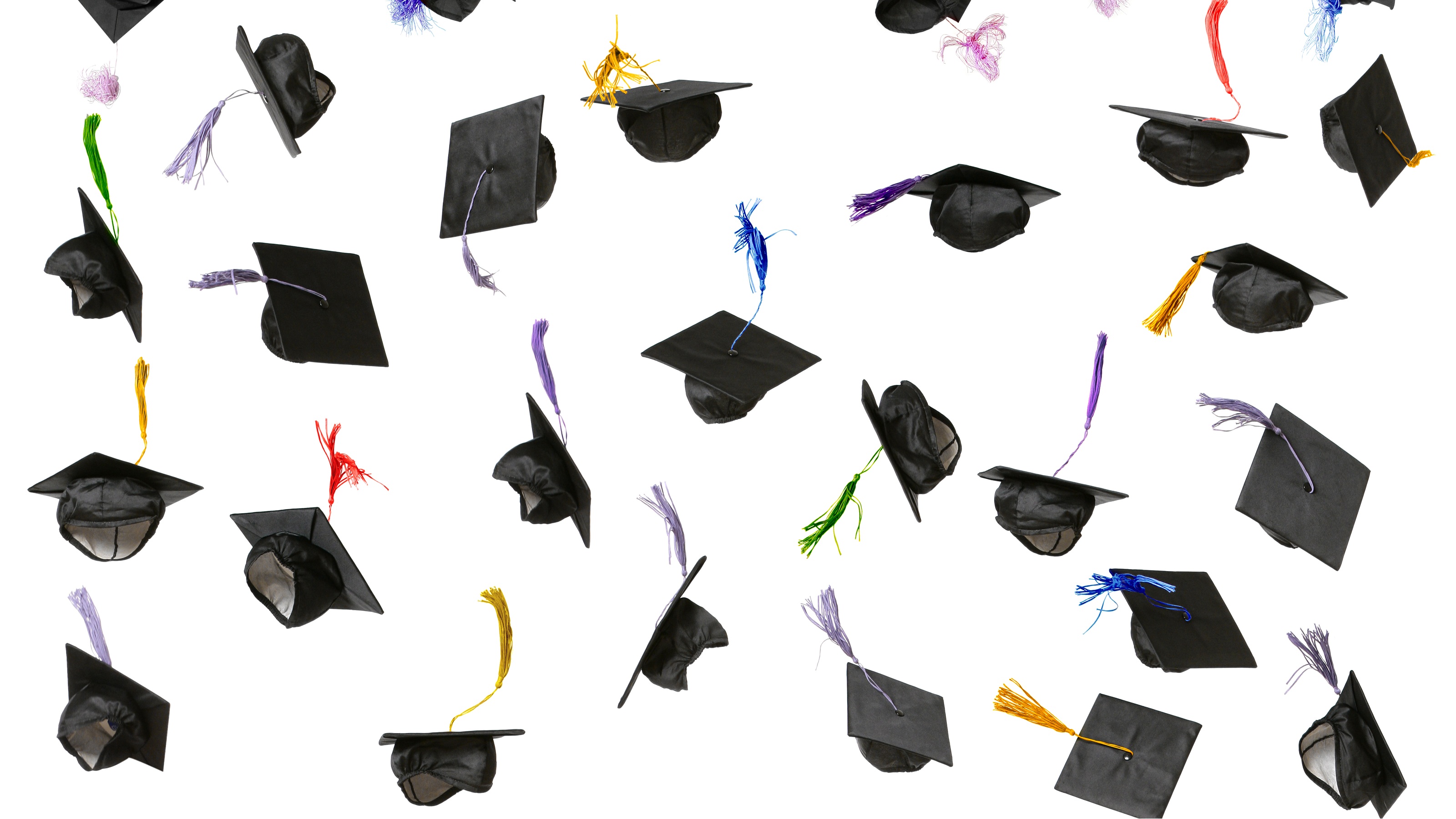 Mortar boards thrown in the air against a white background.