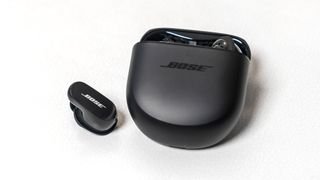 Bose QuietComfort Earbuds II earbud loose next to case.