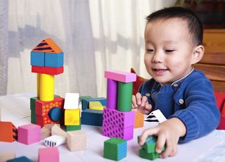 A preschooler plays with blocks