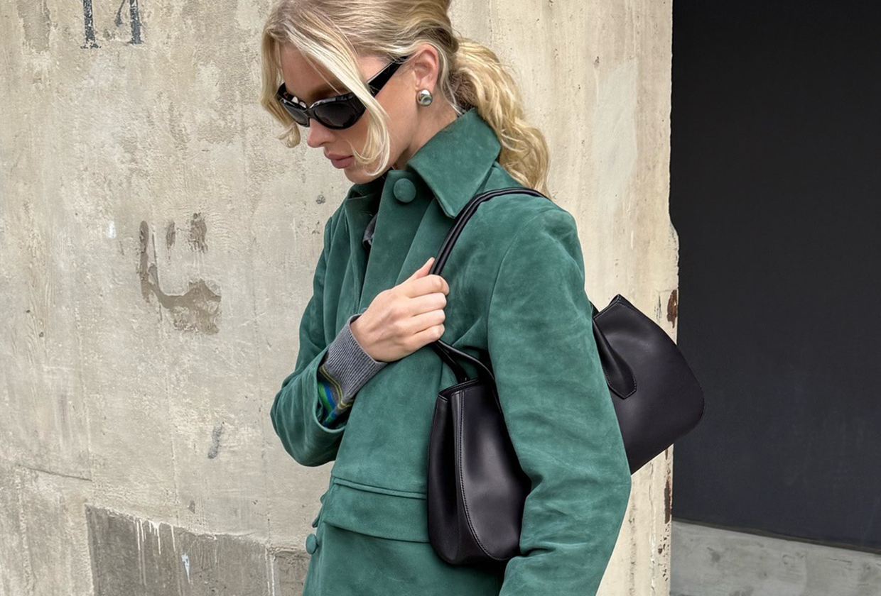 Model Elsa Hosk wears green suede jacket, dark wash jeans, and black almond-toe ballet flats.