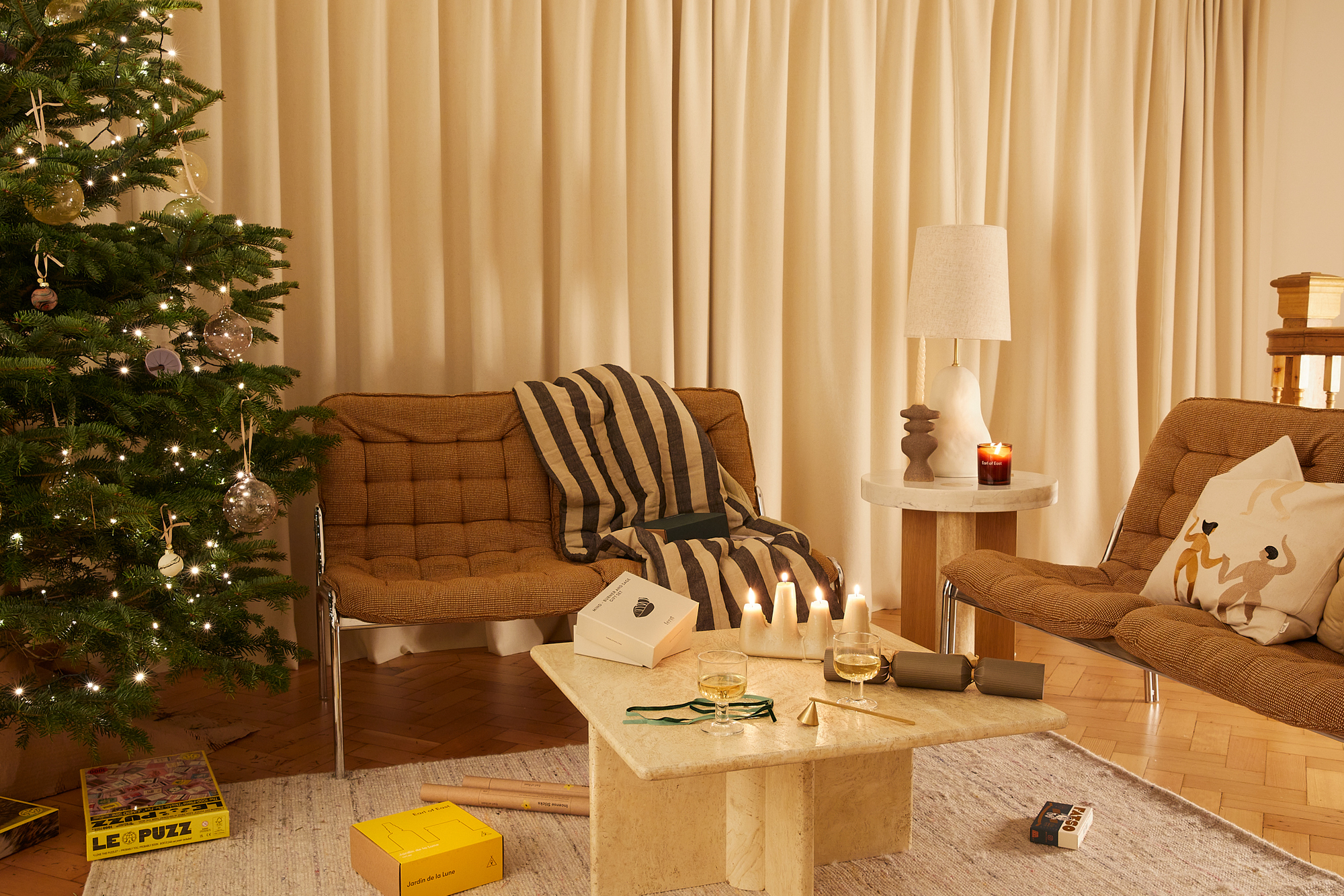 A living room at Christmas with Mid-century modern style sofas and a Christmas tree in the corner