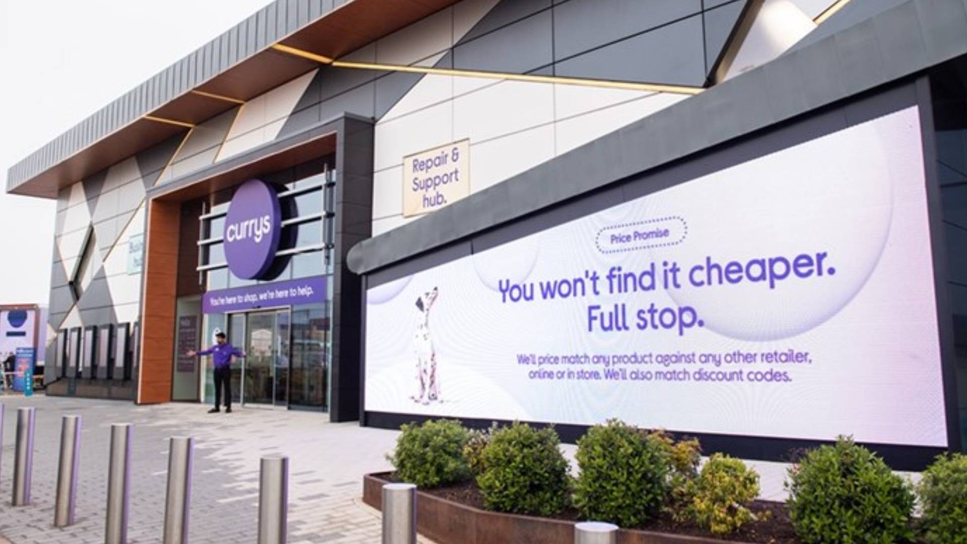 Currys building with signage outside and colleague standing at front door