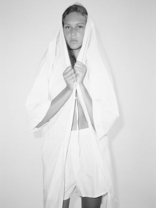 Woman with white cotton shirt over her head in black and white