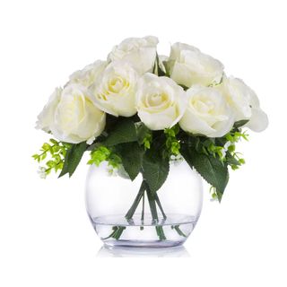 Silk white roses in a small round glass vase