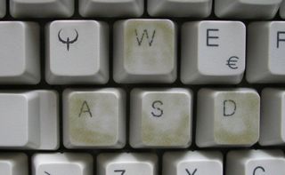 close up of WASD keys on classic beige keyboard, the four are clearly more smudged and worn than their neighbors