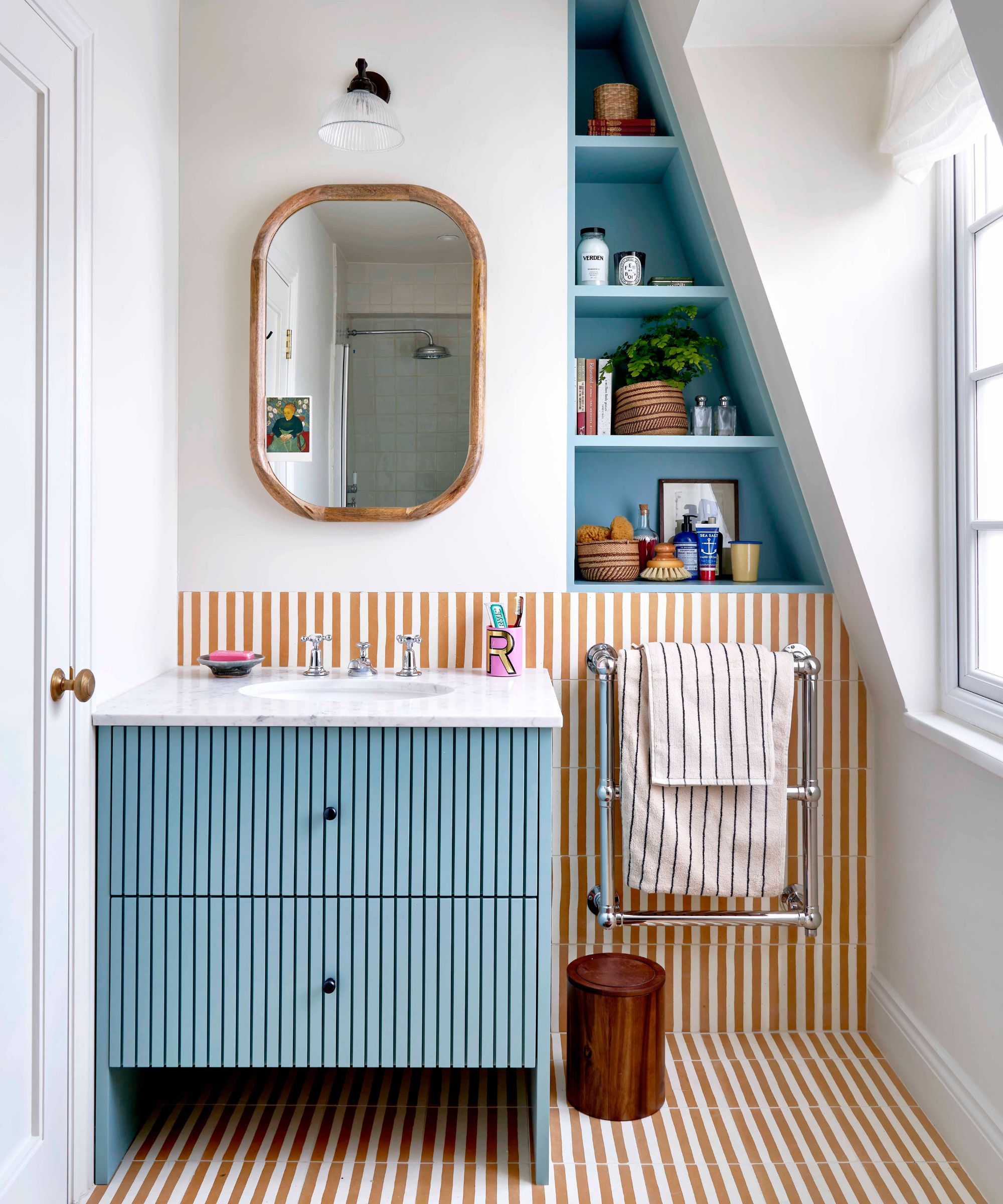 Small bathroom with blue vanity and striped tiles