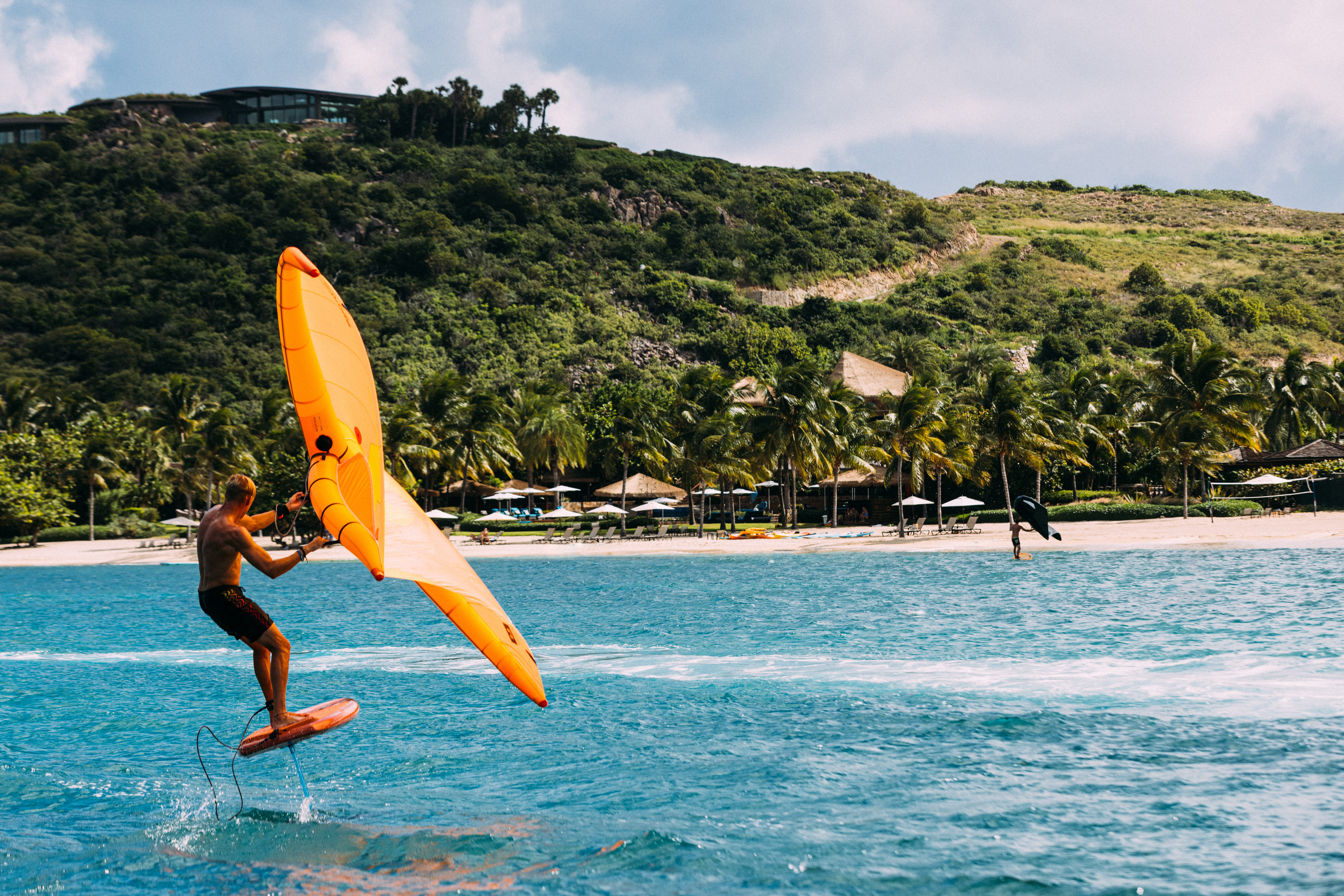A man goes wing foiling in the ocean at Oil Nut Bay