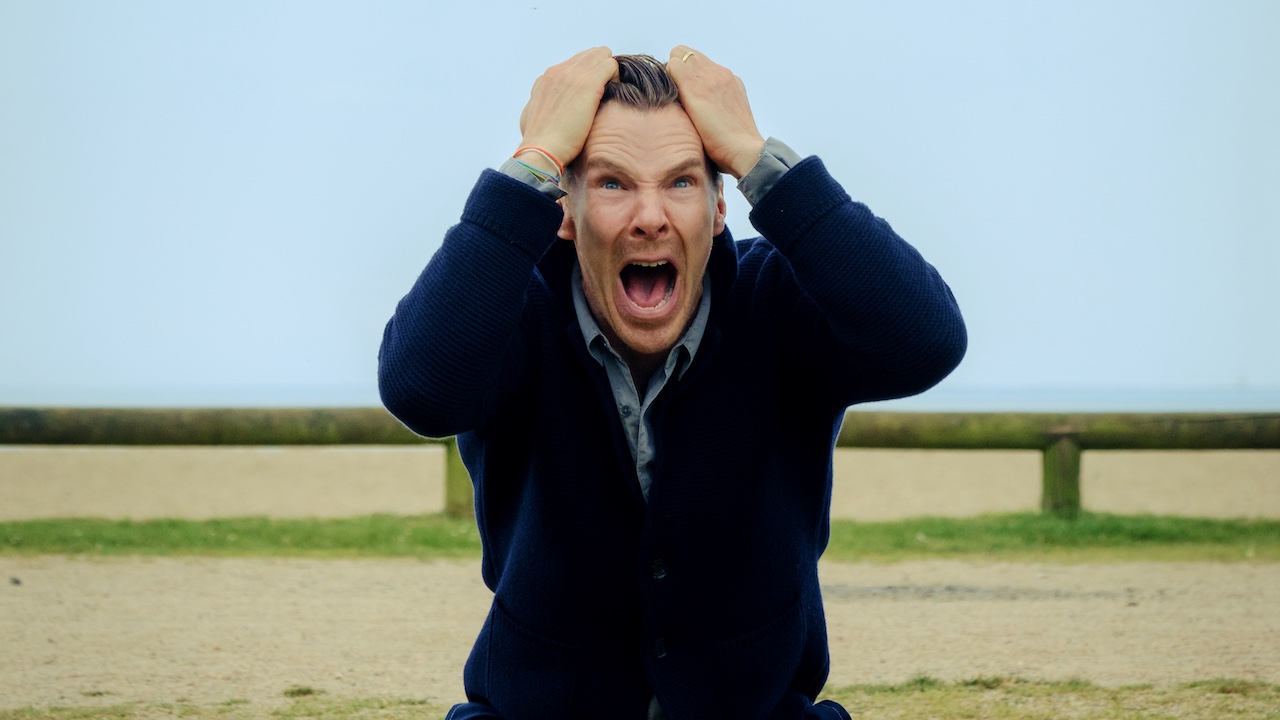 Benedict Cumberbatch yelling in a field with his hands on his head in The Roses