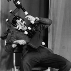 Prince Charles, the Prince of Wales, joking around with a set of bagpipes as he appears on stage in a student revue in 'Quiet Flows the Don', at Trinity College, Cambridge University, February 23rd 1970