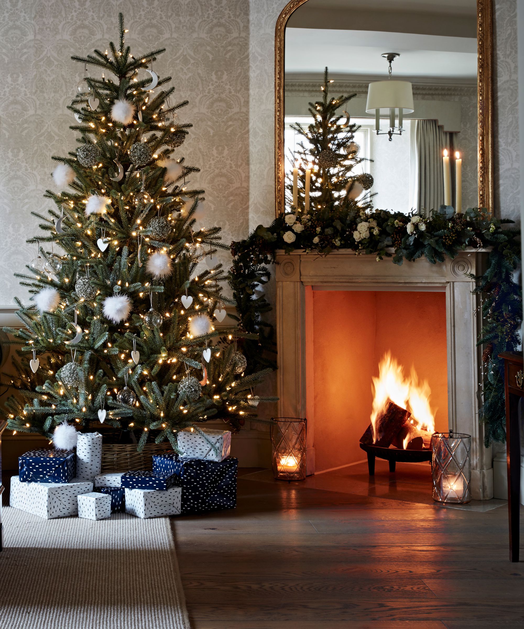 Christmas tree and fireplace with white fluffy ornaments and blue patterned gifts