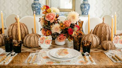 fall table decor with rattan pumpkins, pink florals, taper candlers and placecard