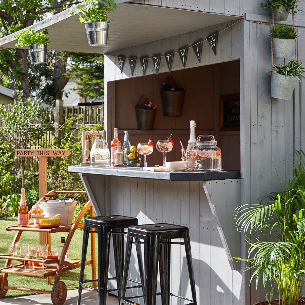 Grey garden shed bar with stools