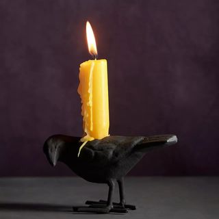 Anthropologie Crow Candle Holder against a dark background.