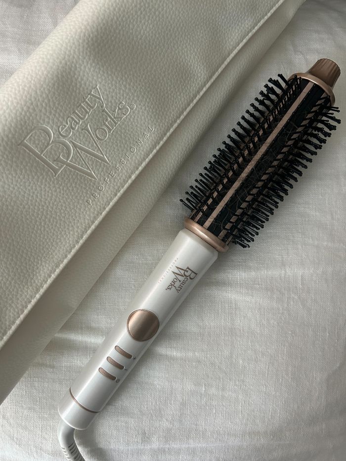 A picture of the Beauty Works hot brush on a white linen background