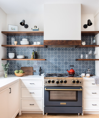 A kitchen with blue backsplash and wooden shelving