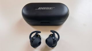 Bose Sport Earbuds review: the earbuds shot from above next to their case