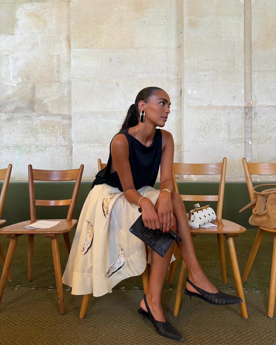@sandrashehab wears slingback kitten heels with a black top and cream midi skirt