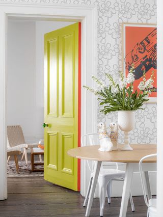 Yellow door in wallpapered dining room