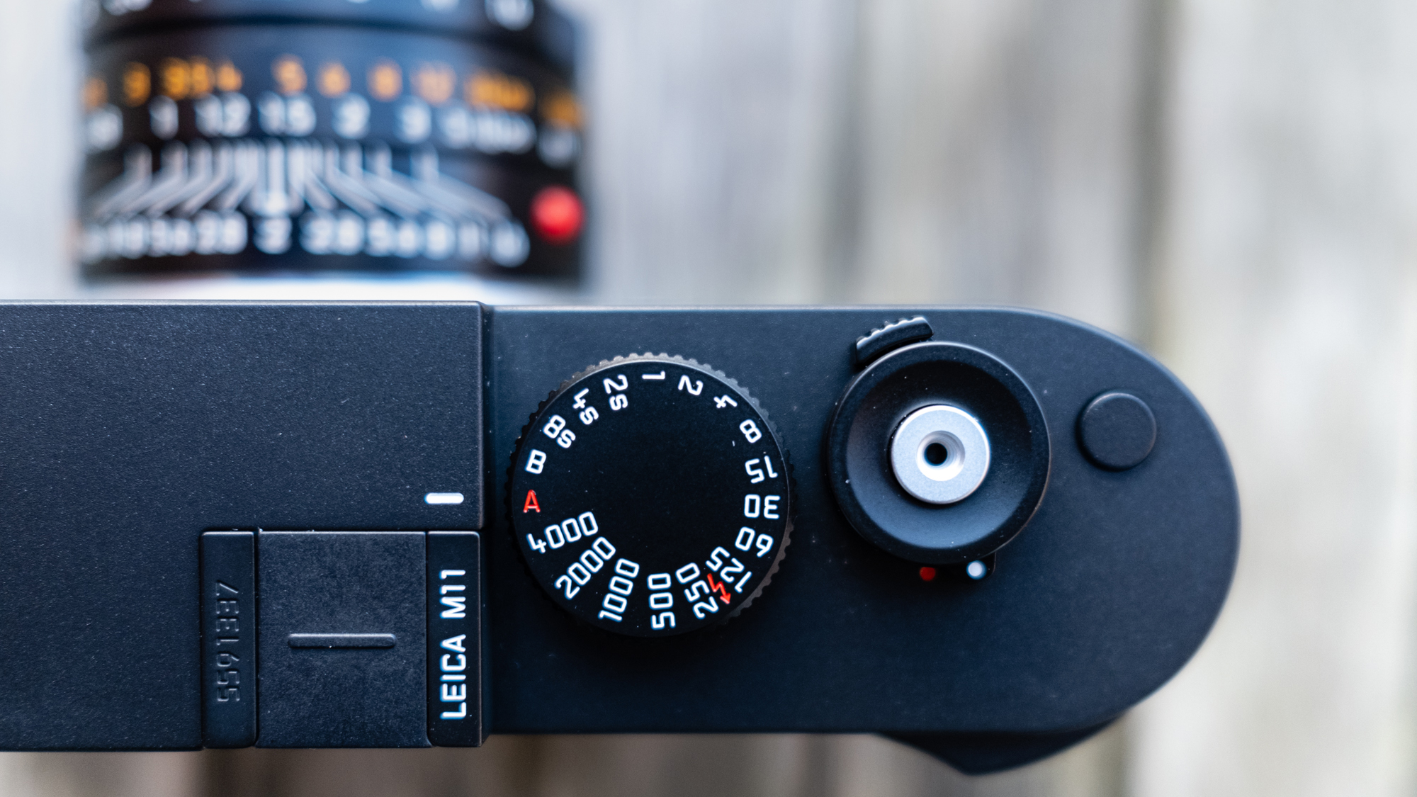 Kamera Leica M11 bertumpu pada bangku kayu