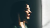 A blurred image of a woman looking out of a window