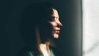 A blurred image of a woman looking out of a window