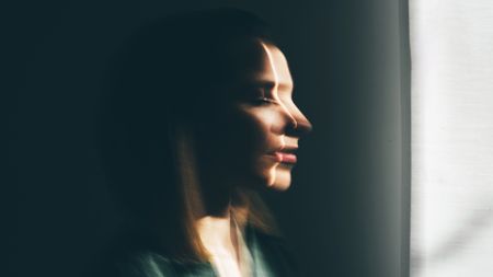 A blurred image of a woman looking out of a window