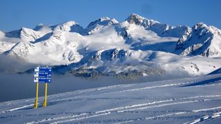 A ski run on Whistler with snowy mountains in the background
