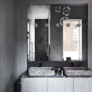 bathroom with large mirror on wall and suspension lights