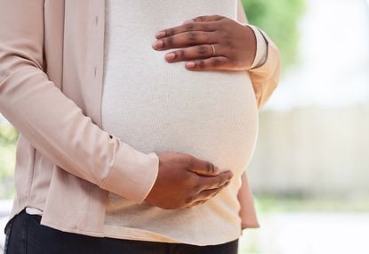 Cropped shot of a mother to be standing in her living room at home