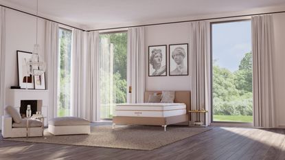 A White Saatva bedroom with large windows, wooden flooring, jute rug, large artworks above the Santorini bedframe, and a white mantelpiece with artworks and cream seating.