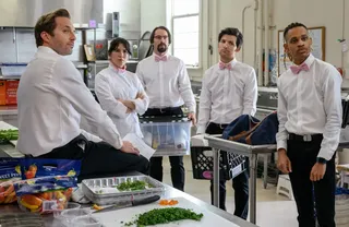 five cater waiters stand around a kitchen in the party down reboot