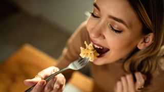 woman eating a forkful of pasta