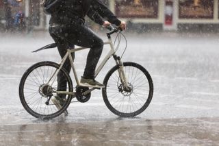 A male cyclist in heavy rain.