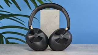 a pair of black bluetooth headphones made by OneOdio Focus A5 is photographed against a blue background