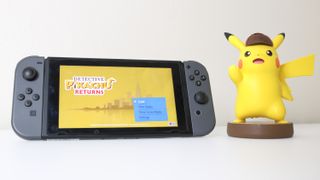 A Detective Pikachu amiibo next to a Nintendo Switch with Detective Pikachu Returns on the screen