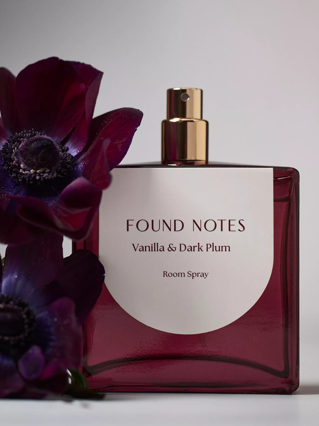 A burgundy bottle of vanilla and dark plum room spray from Anthropologie
