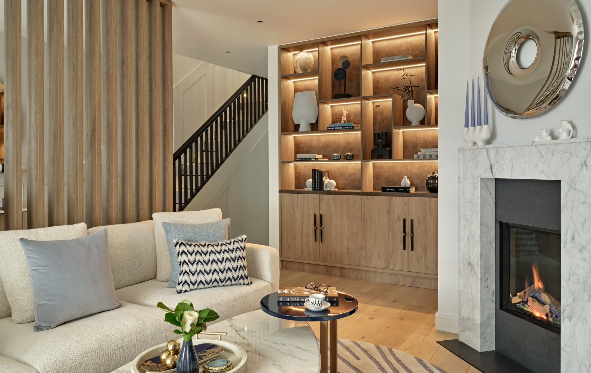living room with fireplace, built in wooden storage and cream sofas