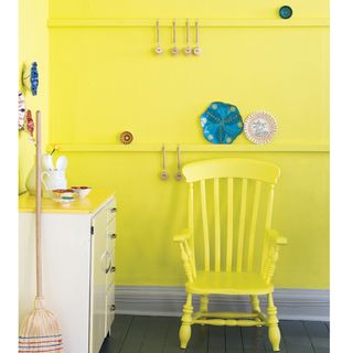 yellow wall with white cabinet wooden flooring and yellow chair